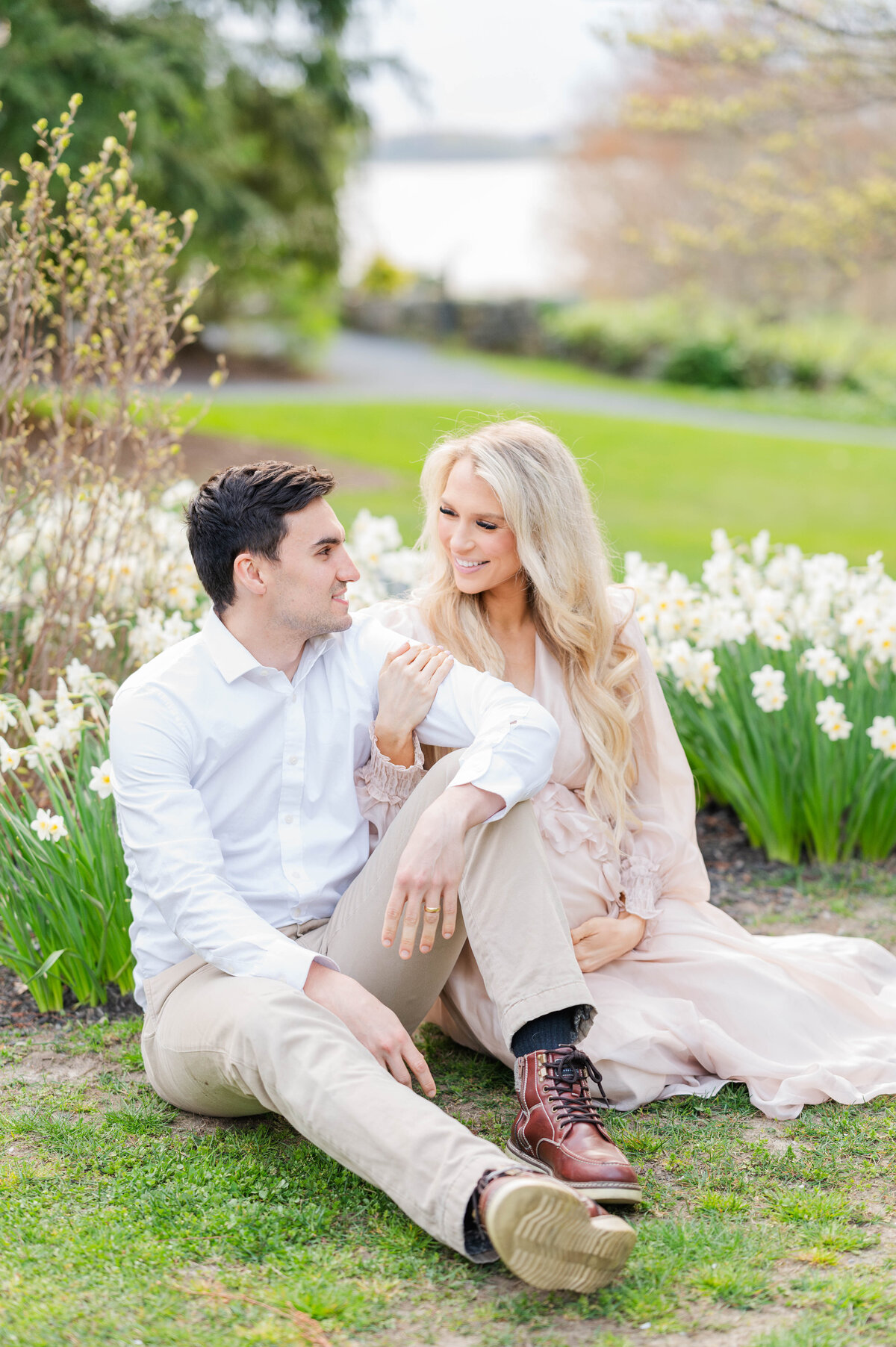 Husband and wife smiling at each other in Bristol, RI at Blithewold Mansion taken by best Maternity photographer in Rhode Island