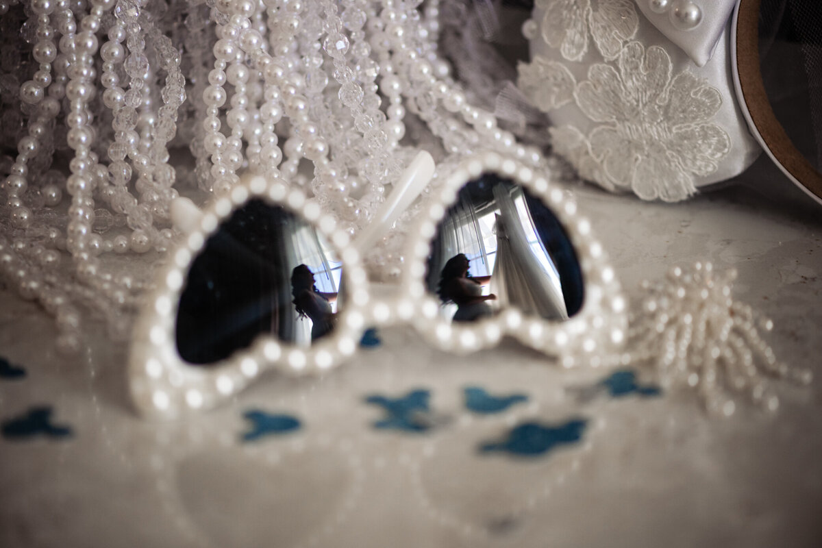 Bride getting ready with reflection on heart beaded glassses