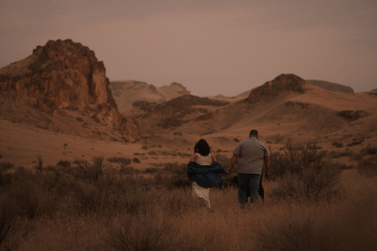 overland elopement couple run off into the distance in the Moab, Utah desert during sunset