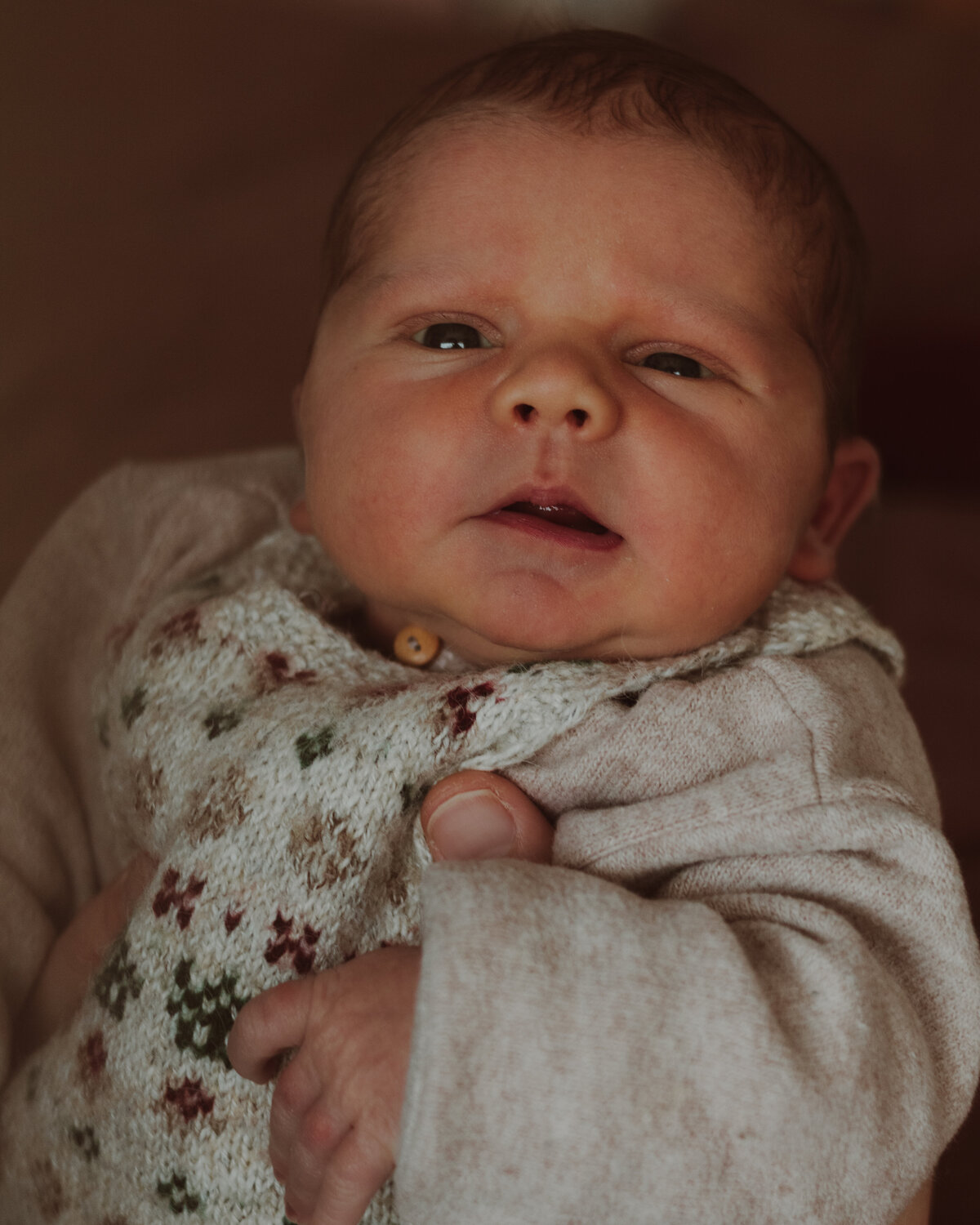 en baby wordt liefdevol vastgehouden door een persoon, die zorg en genegenheid uitstraalt.