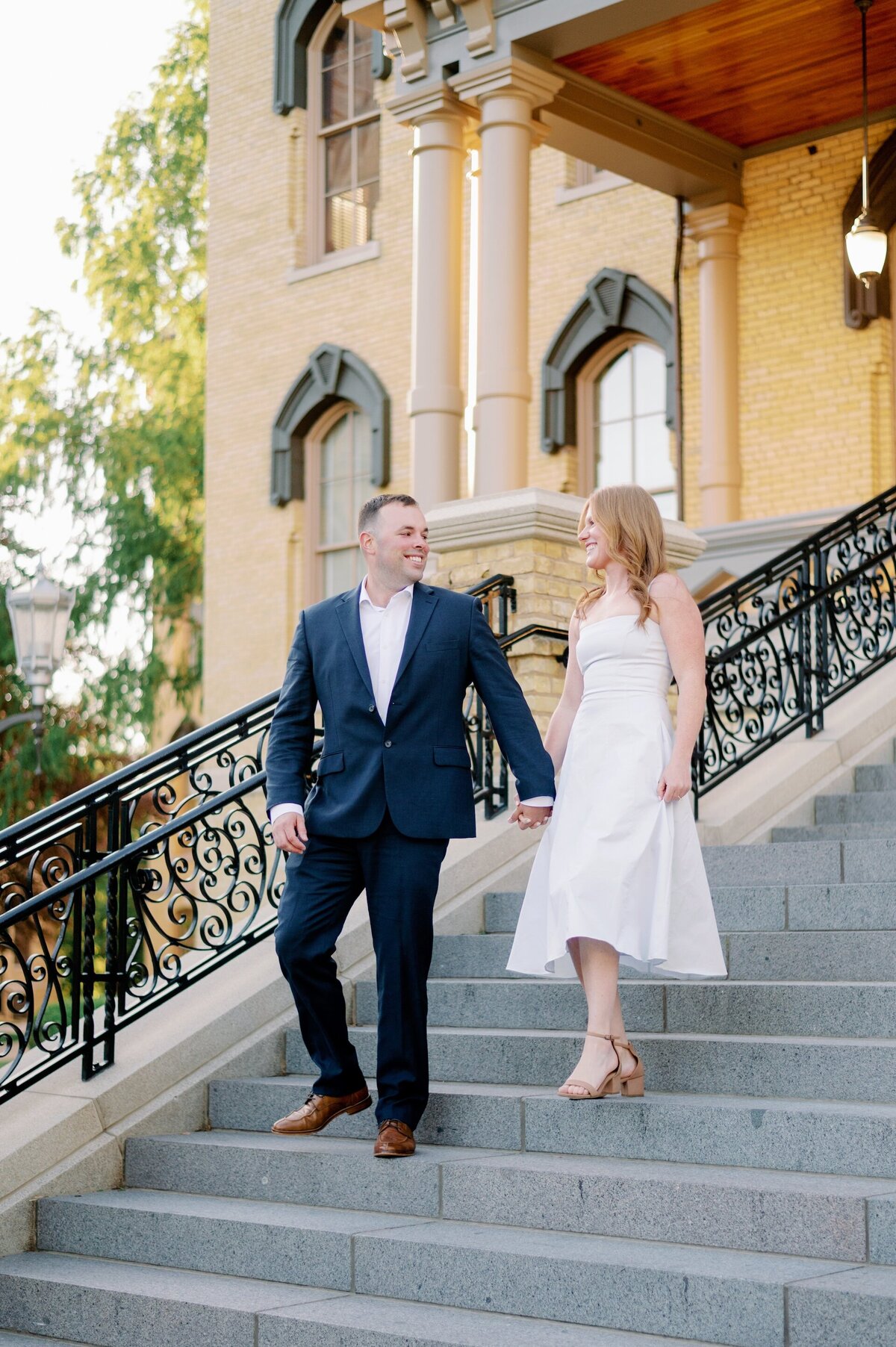 engaged couple walking down steps together
