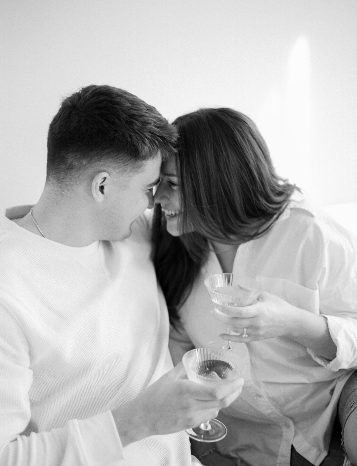 couple nuzzles smiling, white natural light studio, film branding photographer in Michigan