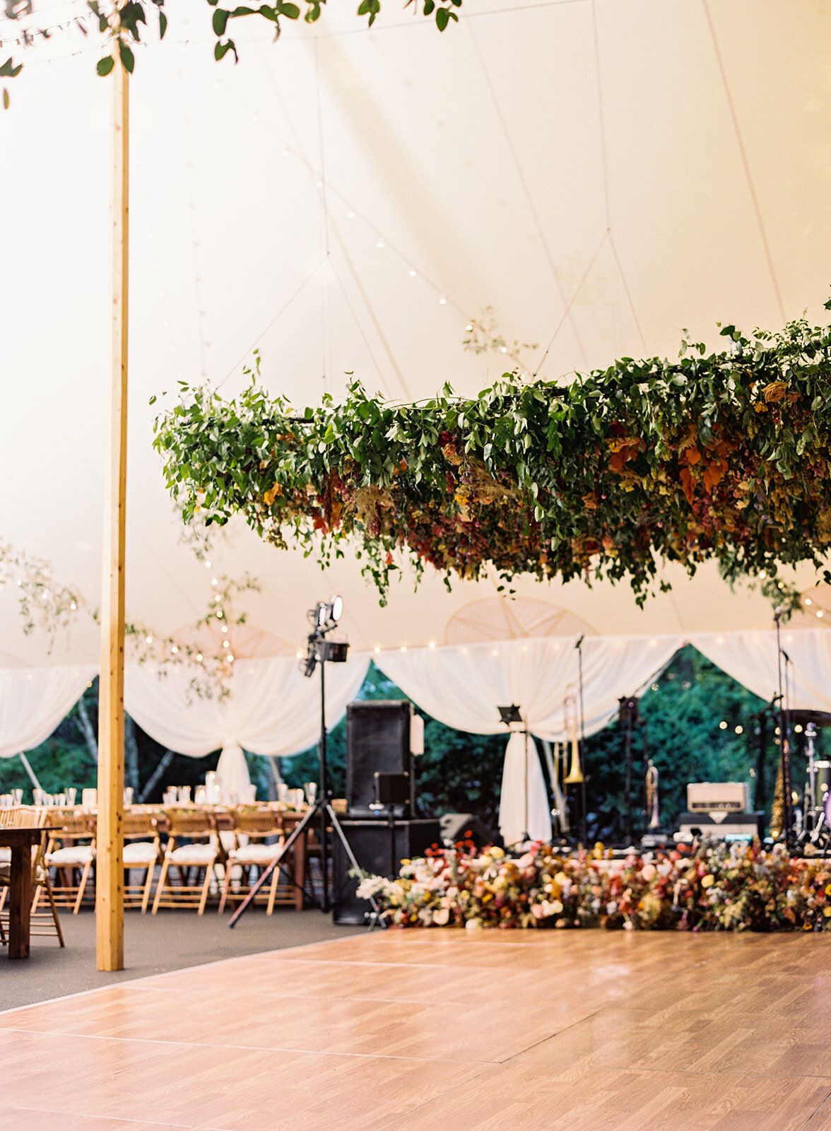 An oversized square hanging flower installation over the dance floor is a great alternative to a floral chandelier! Lush smilax vines, hops, copper beech, and bright wildflowers. RT Lodge and Nashville wedding floral designer.
