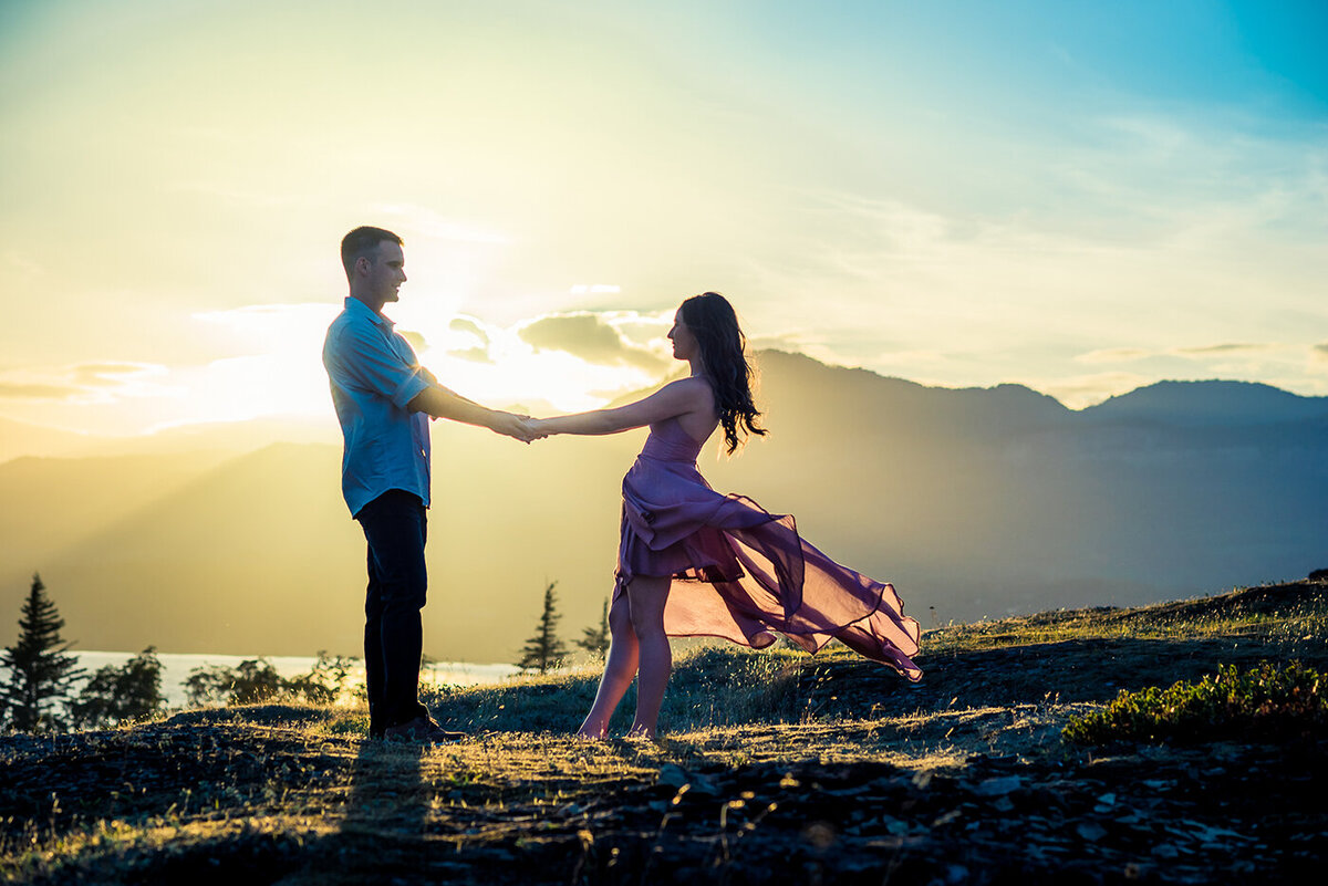 engaged couple holding hands in light