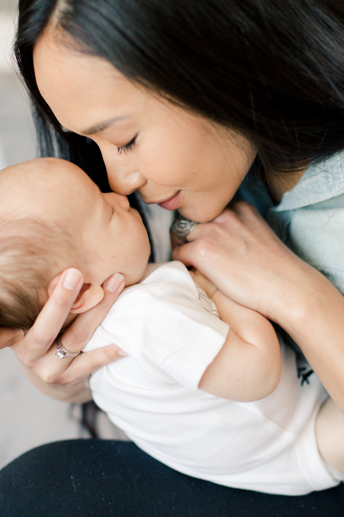 mom holds newborn baby to nose for newborn photography rochester minnesota