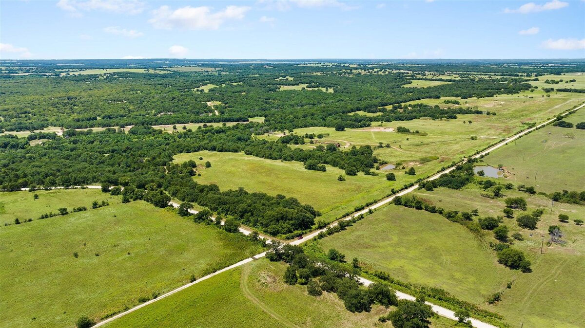 Aerial view of 55-acre property with mature post oaks in Saint Jo, TX