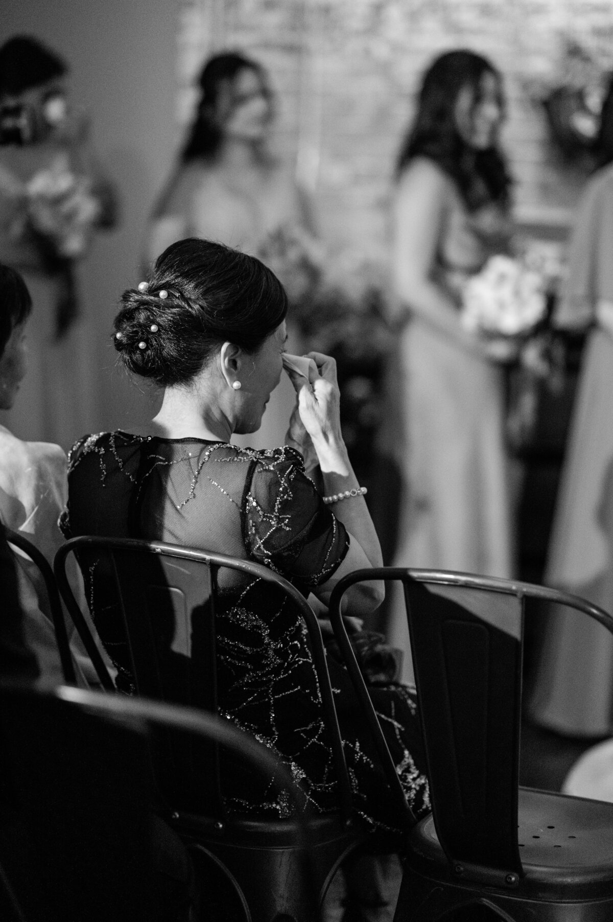 Family member wipes tear from eye during ceremony