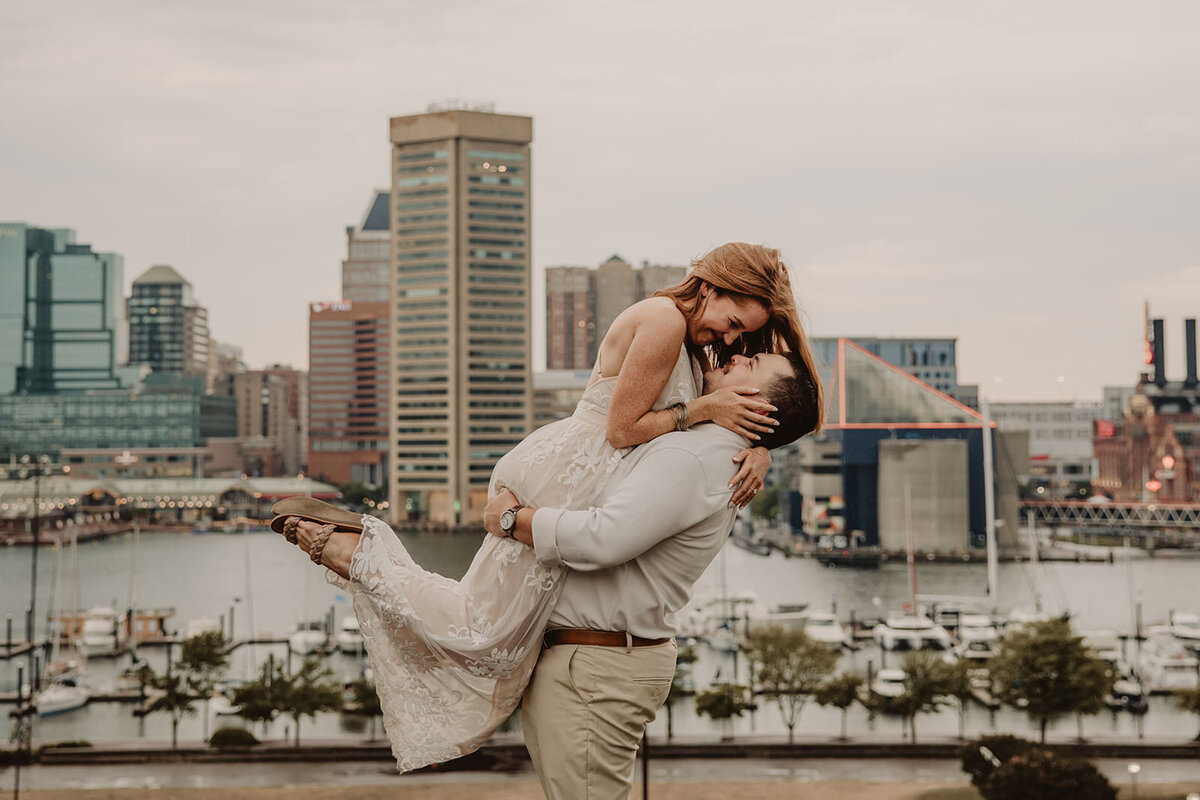 A person lifting up their partner as they lean in to kiss 