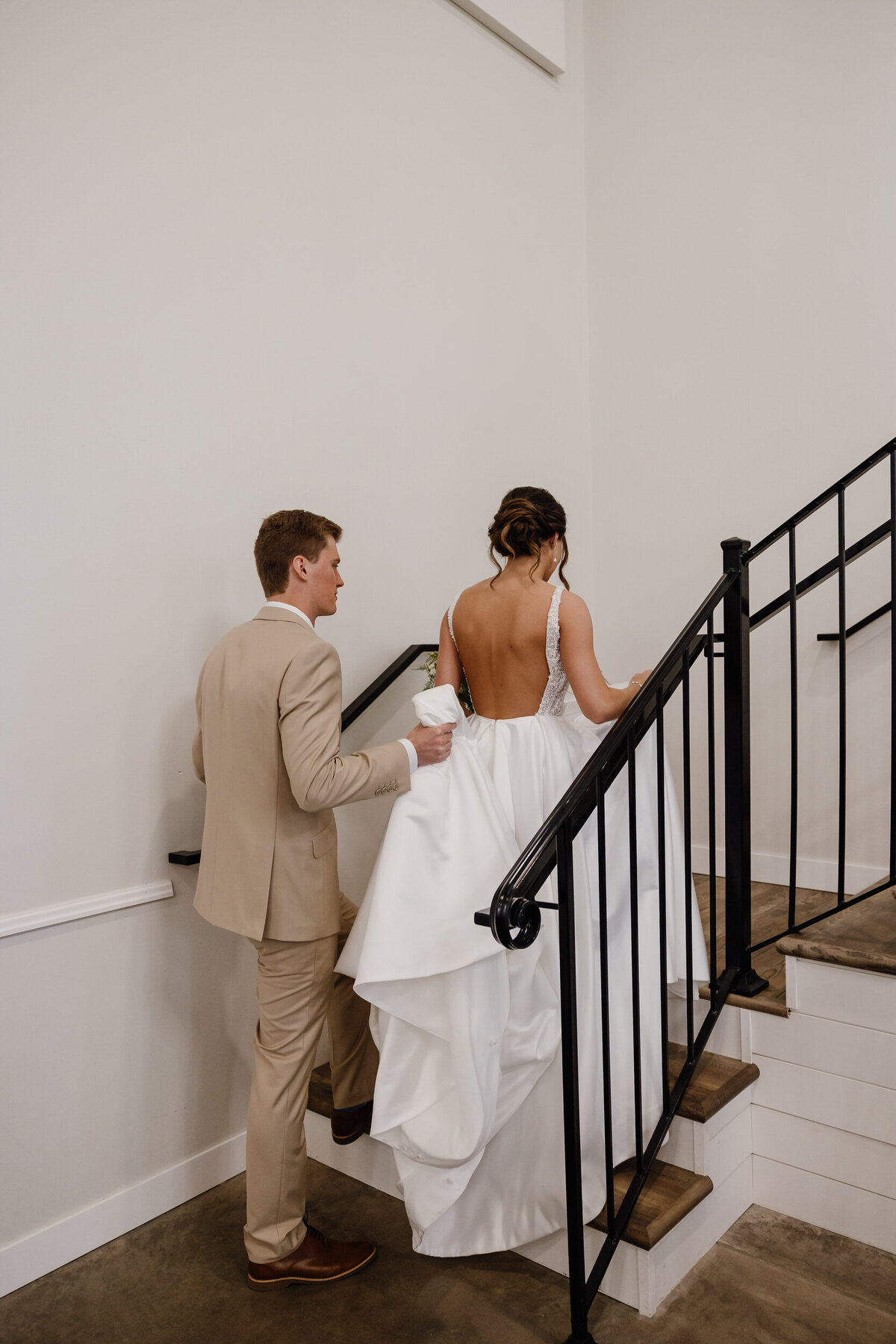 A newlywed couple walking up the stairs together