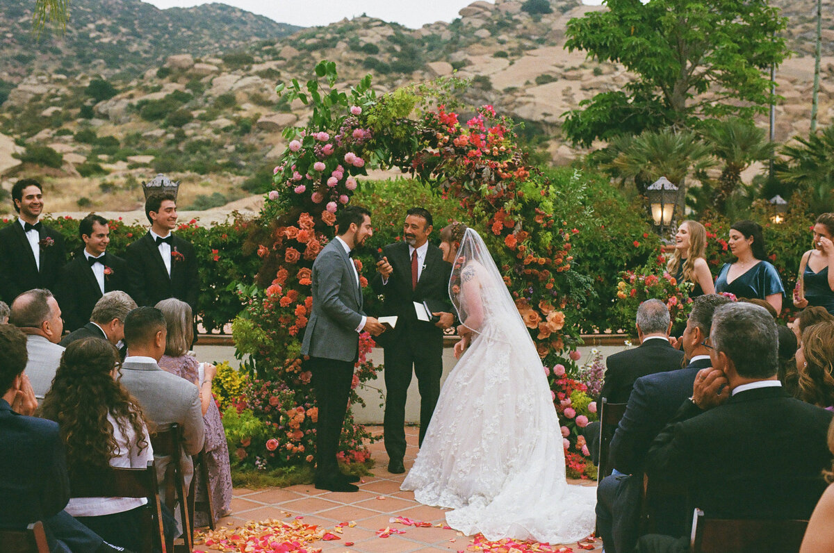 A bride and groom standing up saying their vows.