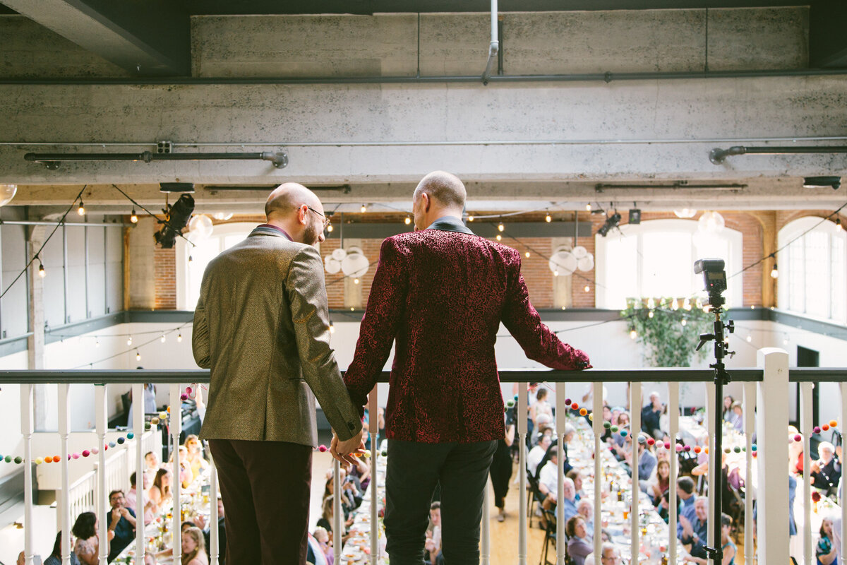 Couple leaning on the railings looking at the guests at the ground floor