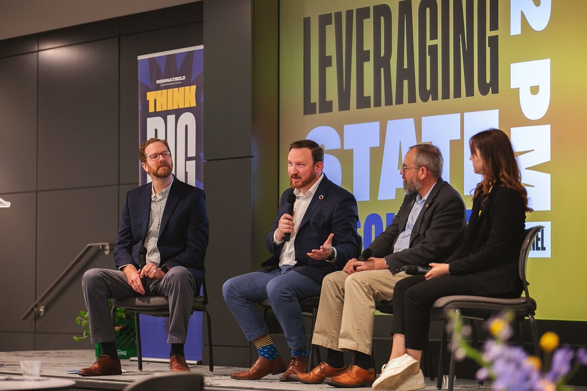  four-professionals-engaging-in-a-panel-discussion-at-a-conference-in-indianapolis-sharing-insights-on-business-growth