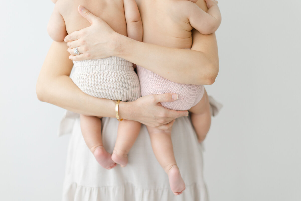 Mother holds twin babies