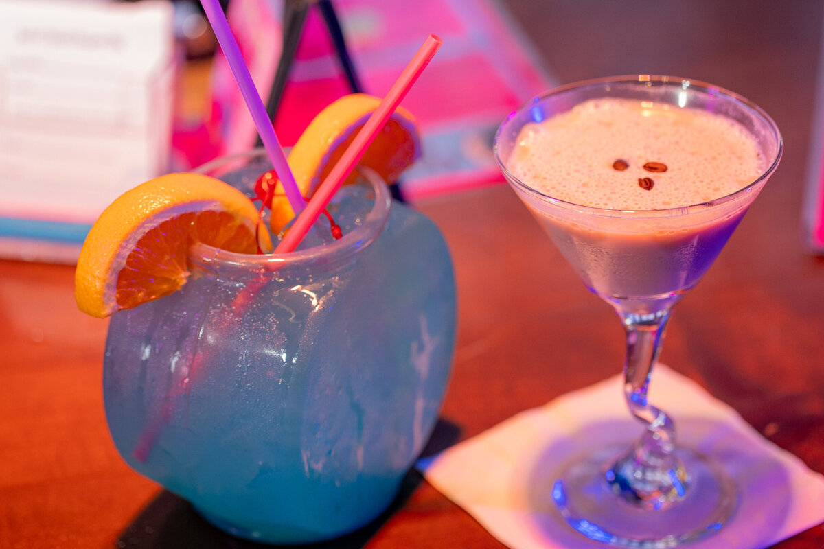 Two cocktails sitting on a bar together