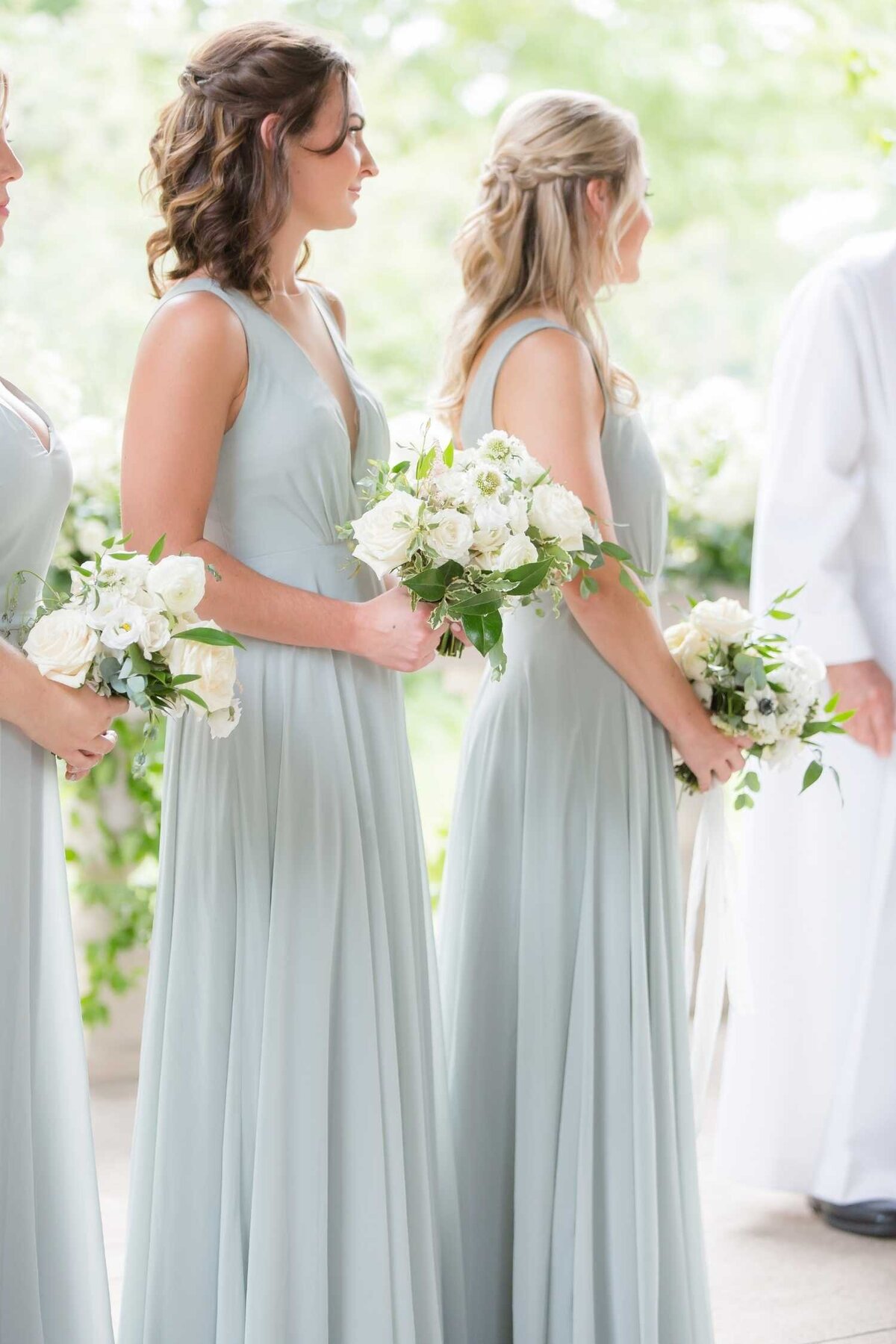 Bridesmaids with lush green and white garden bouquets during the ceremony at Luxury Chicago Outdoor Historic Wedding Venue.