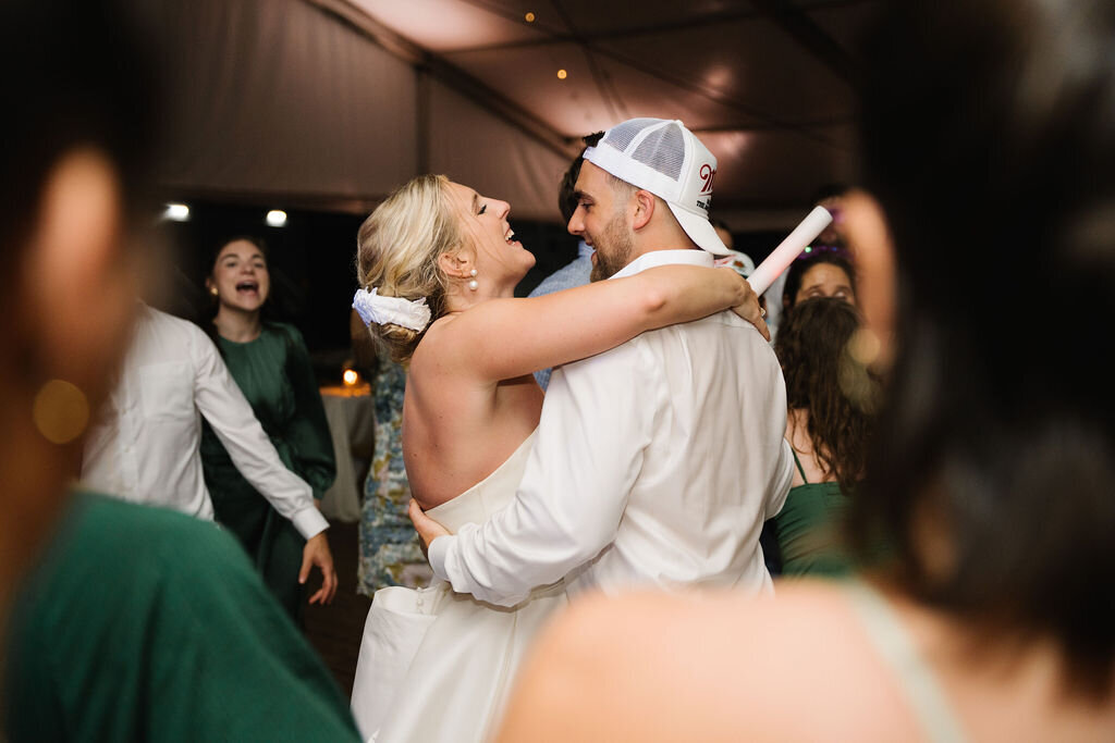 Bride and groom dancing at their wedding reception with arms around each other