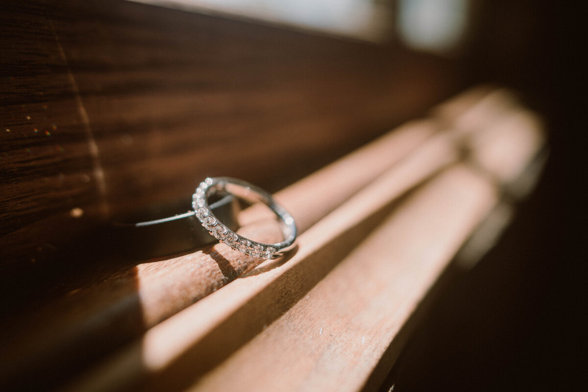 wedding rings sit on wooden window ledge
