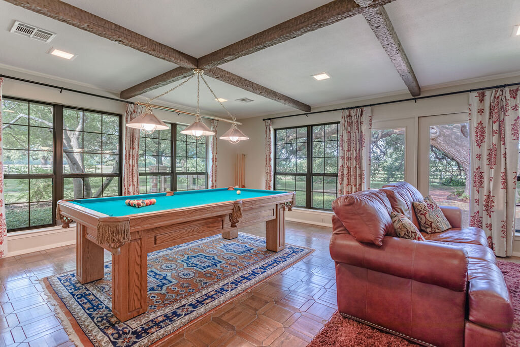 Living room with comfortable seating and pool table in this 5-bedroom, 4-bathroom vacation rental house for 16+ guests with pool, free wifi, guesthouse and game room just 20 minutes away from downtown Waco, TX.