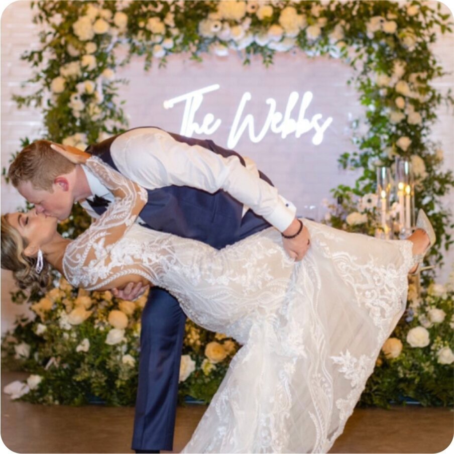 couple dipping in front of their neon sign