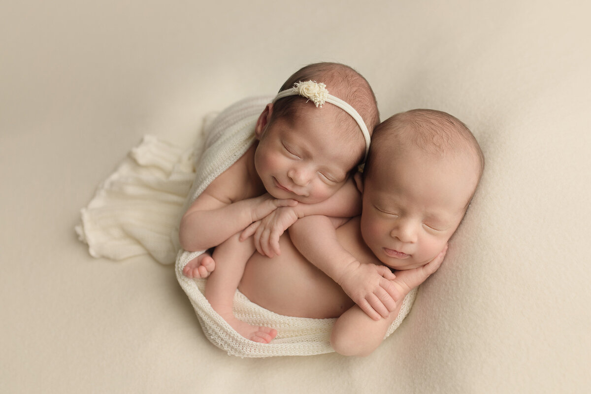 newborn twins asleep on top of each other
