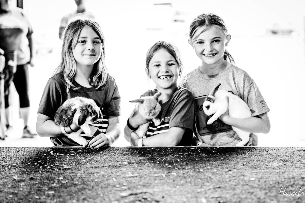 three girls smiling holding bunnies during clover kids show