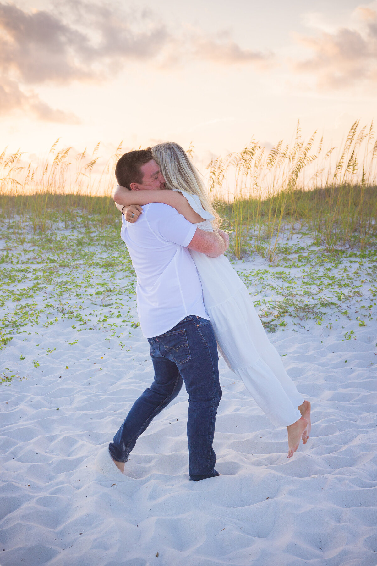 guy twirls girl and beach proposal