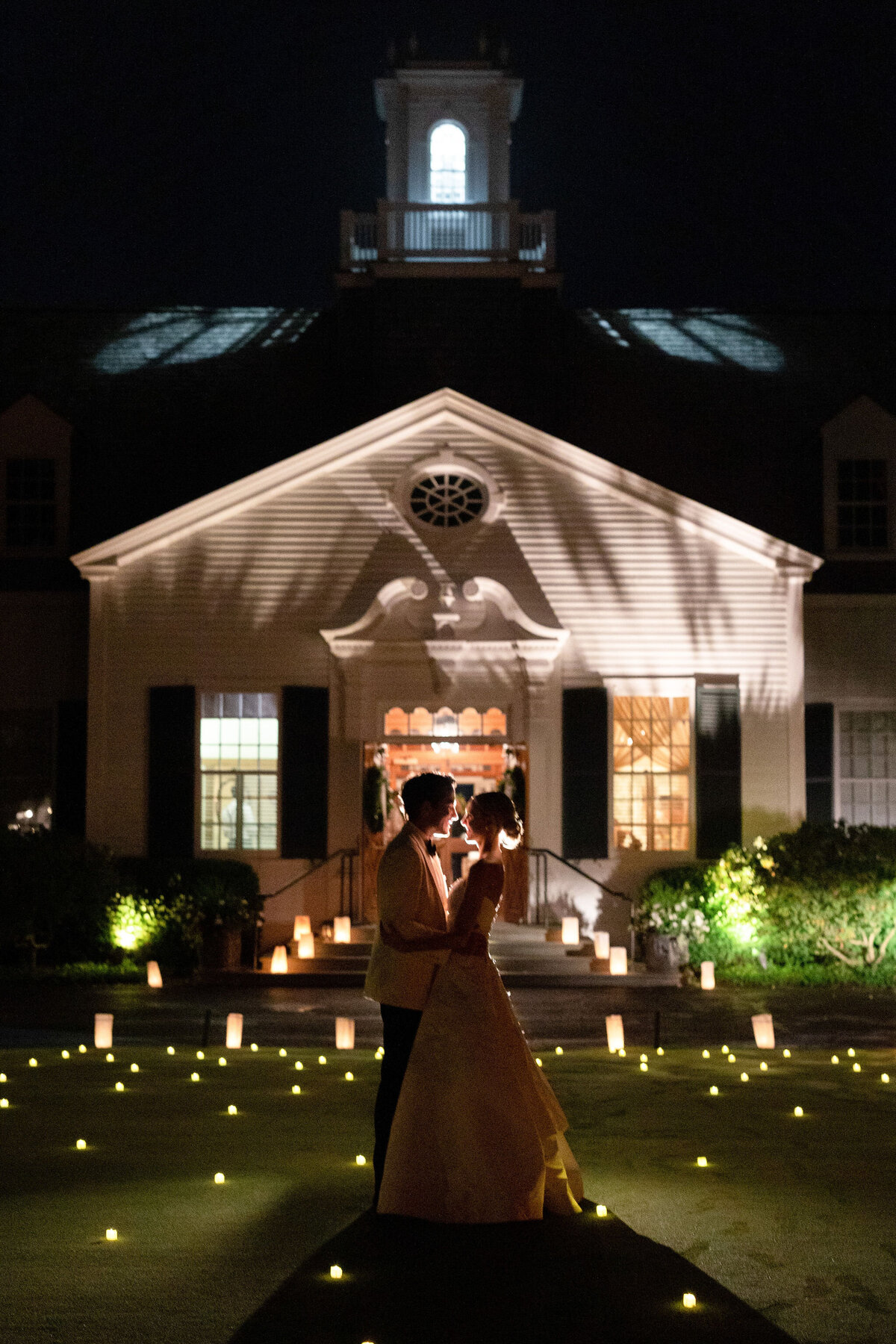 A nighttime picture of the bride and groom about to kiss outside the Shoreacres Country Club.