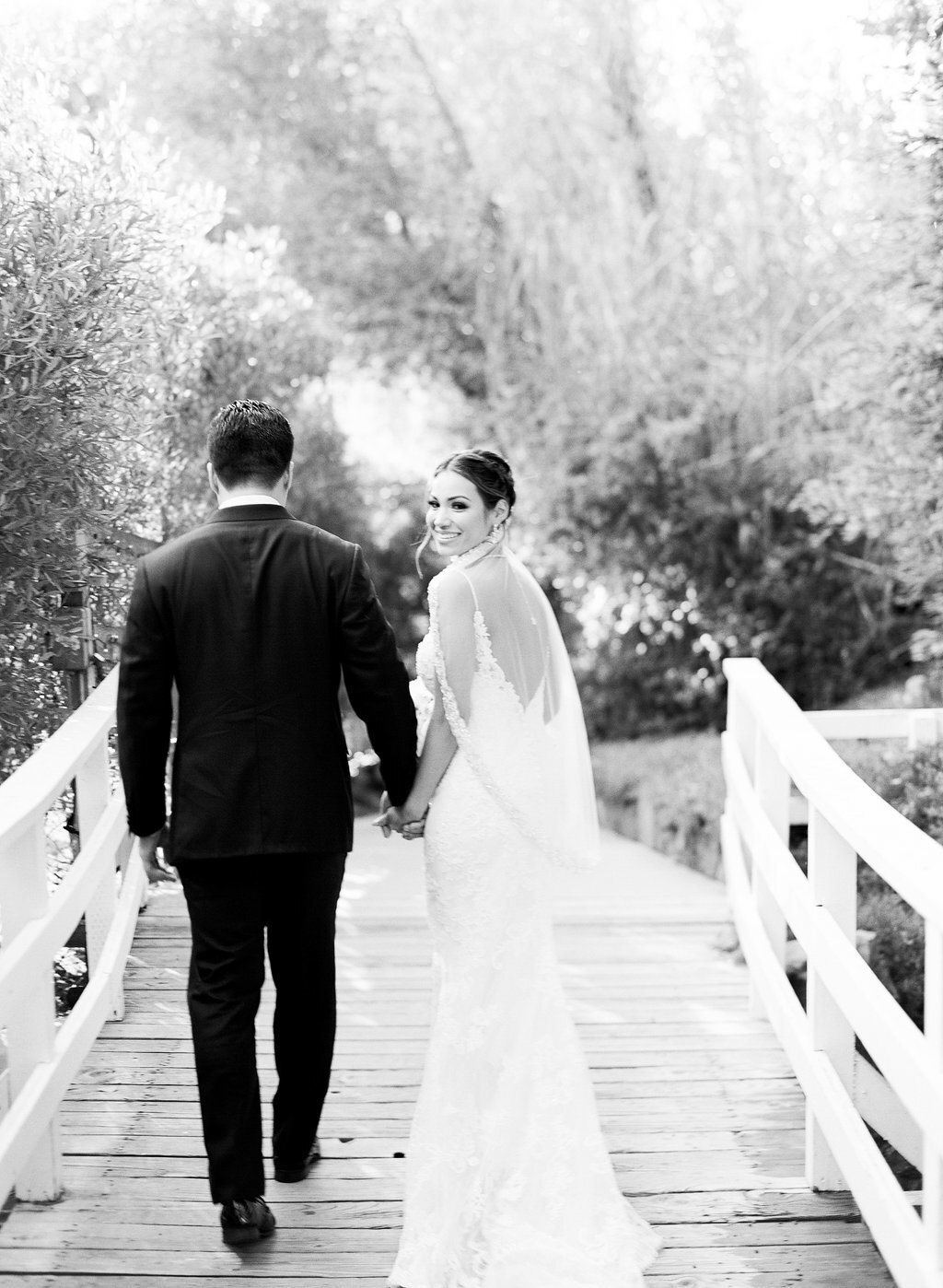 bride and groom walking on a bridge