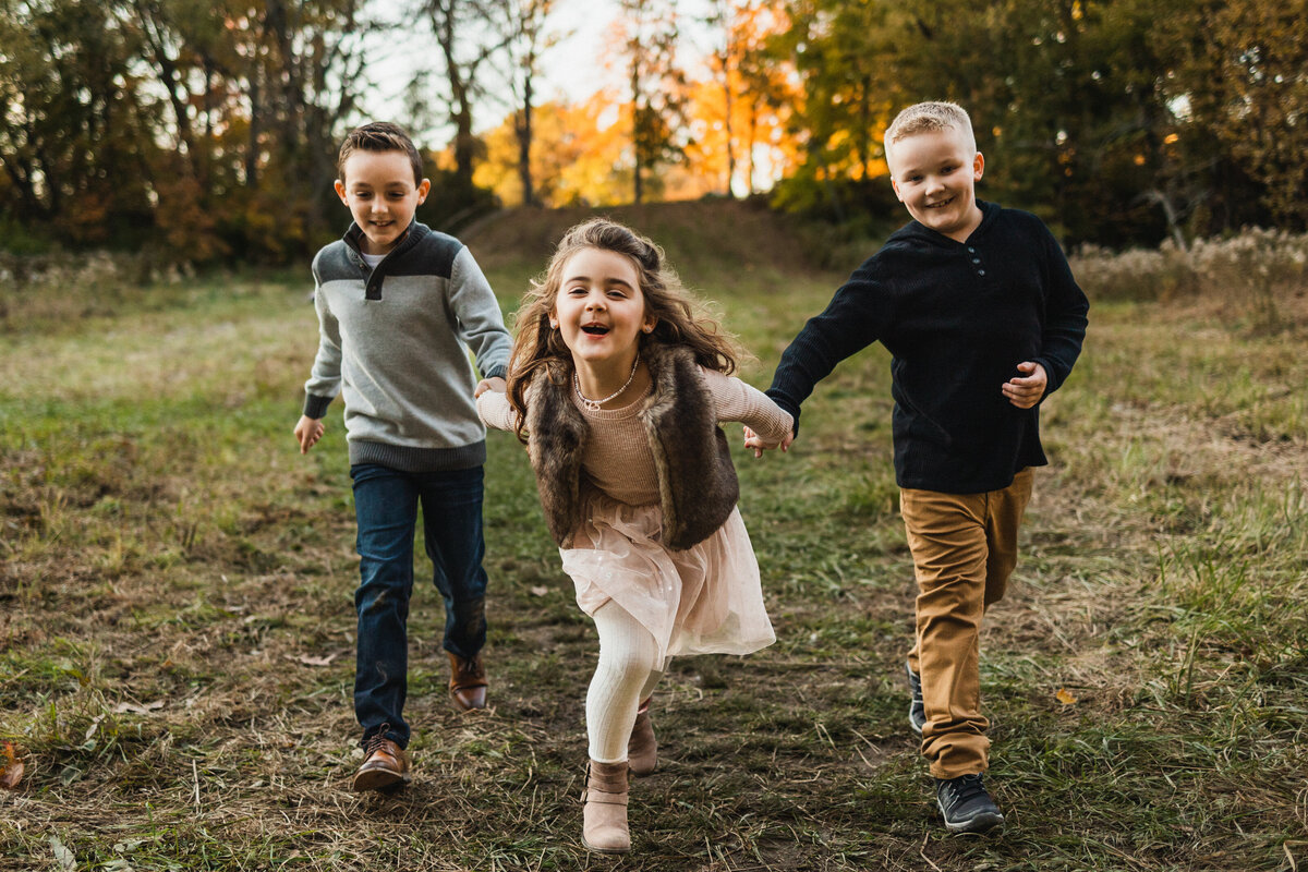 Three kids running in a field