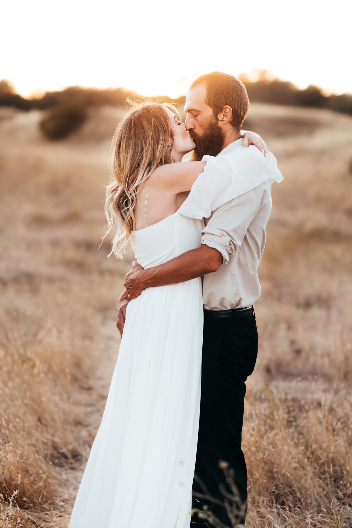Couple kissing in a golden field — view couples photo gallery