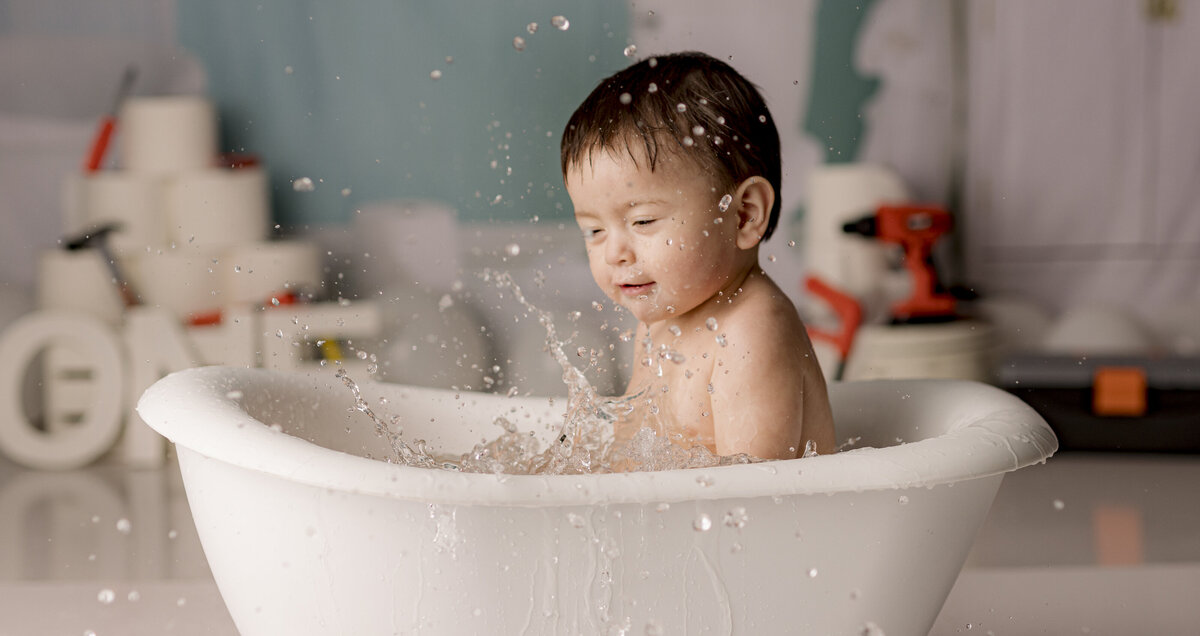 baby splashing in mini clawfoot tub