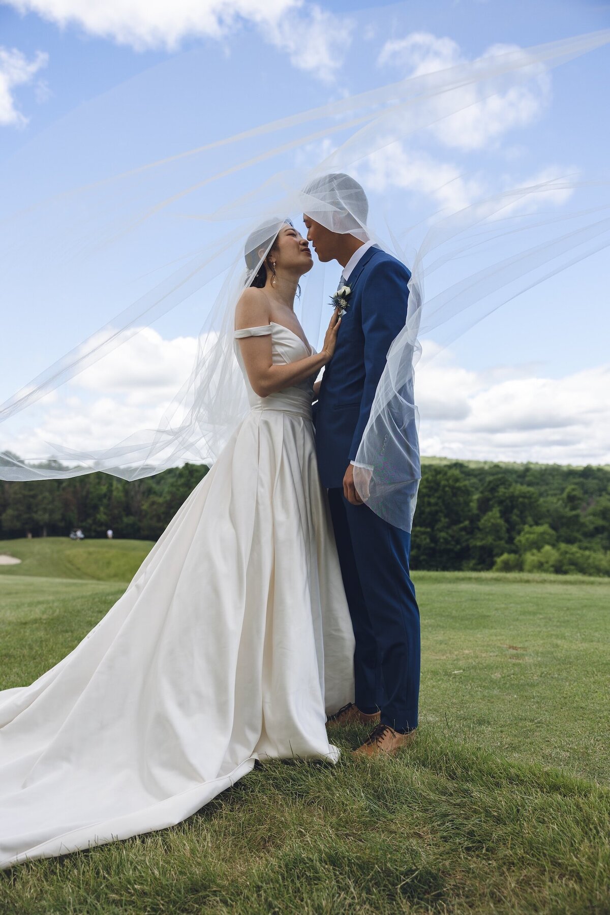 Romantic couple portrait with bride’s veil blowing in breeze