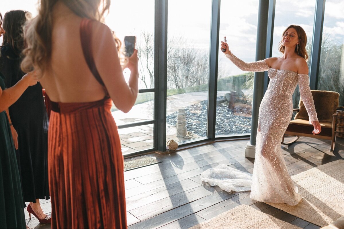 Bride applies perfume at Gara Rock hotel in winter sunlight