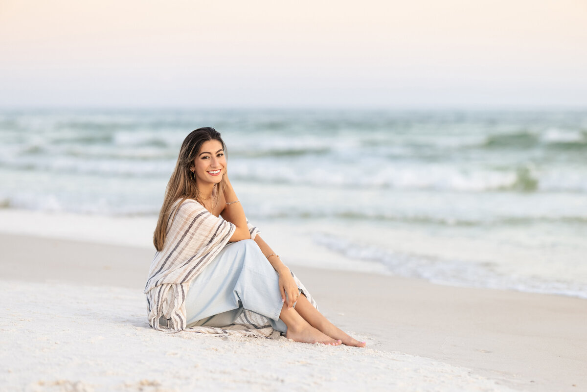 A girl sitting on a sandy beach