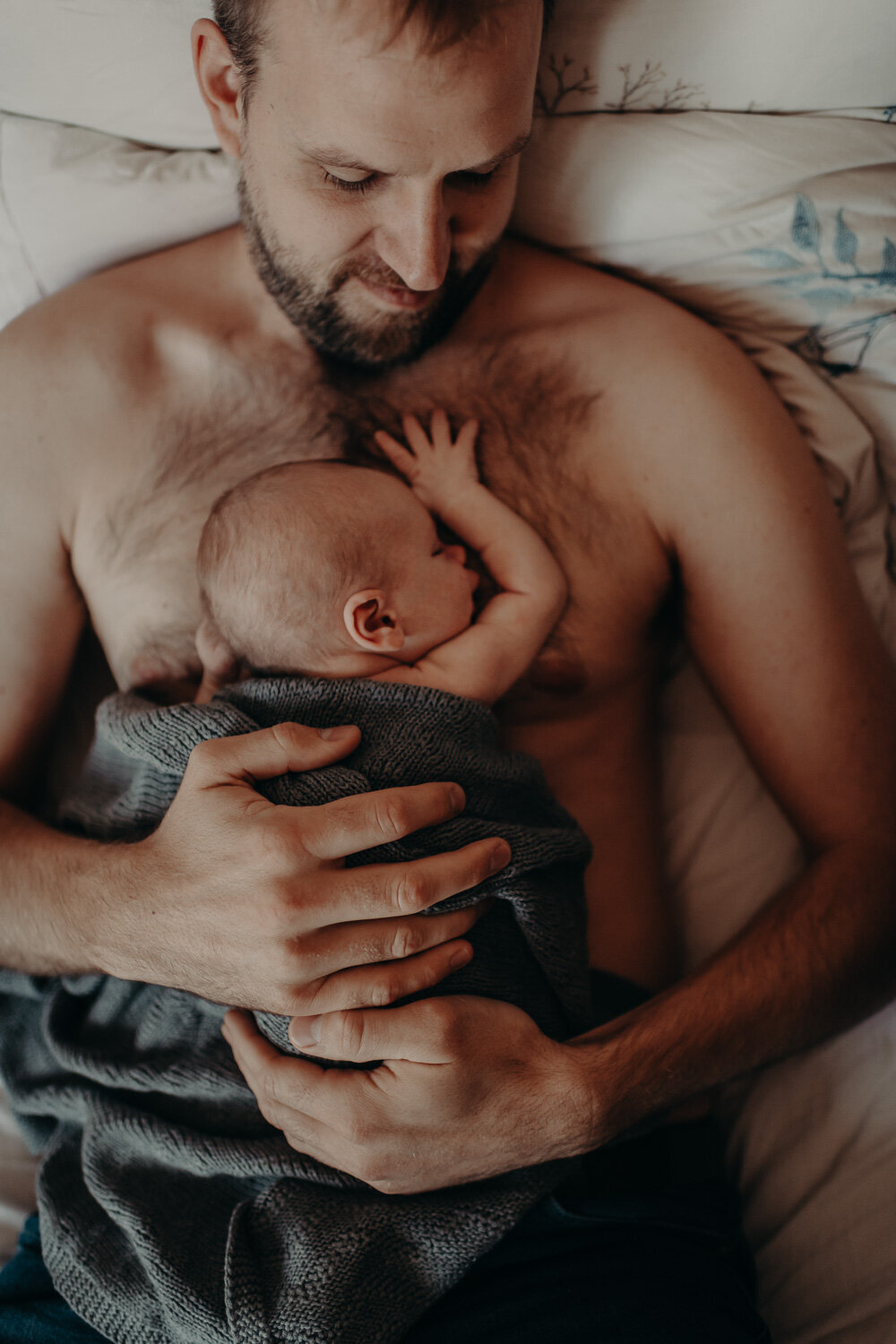 Newborn baby lying on fathers chest