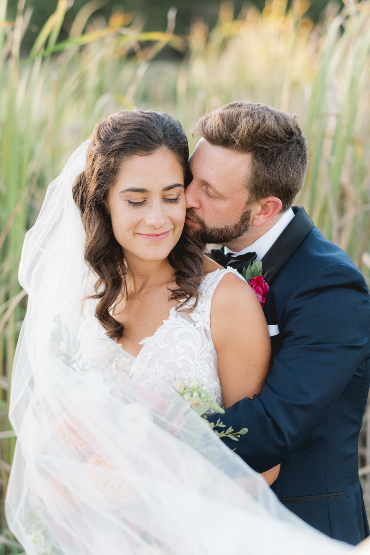 wedding couple in Pnina Tornei gown and navy tuxedo hugging on wedding day