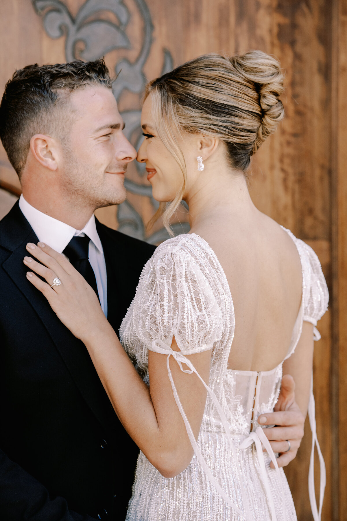 Bride in updo and short sleeved beaded wedding gown with bows and groom at Palais Namaskar Morocco for a destination wedding photographed by Italy photographer