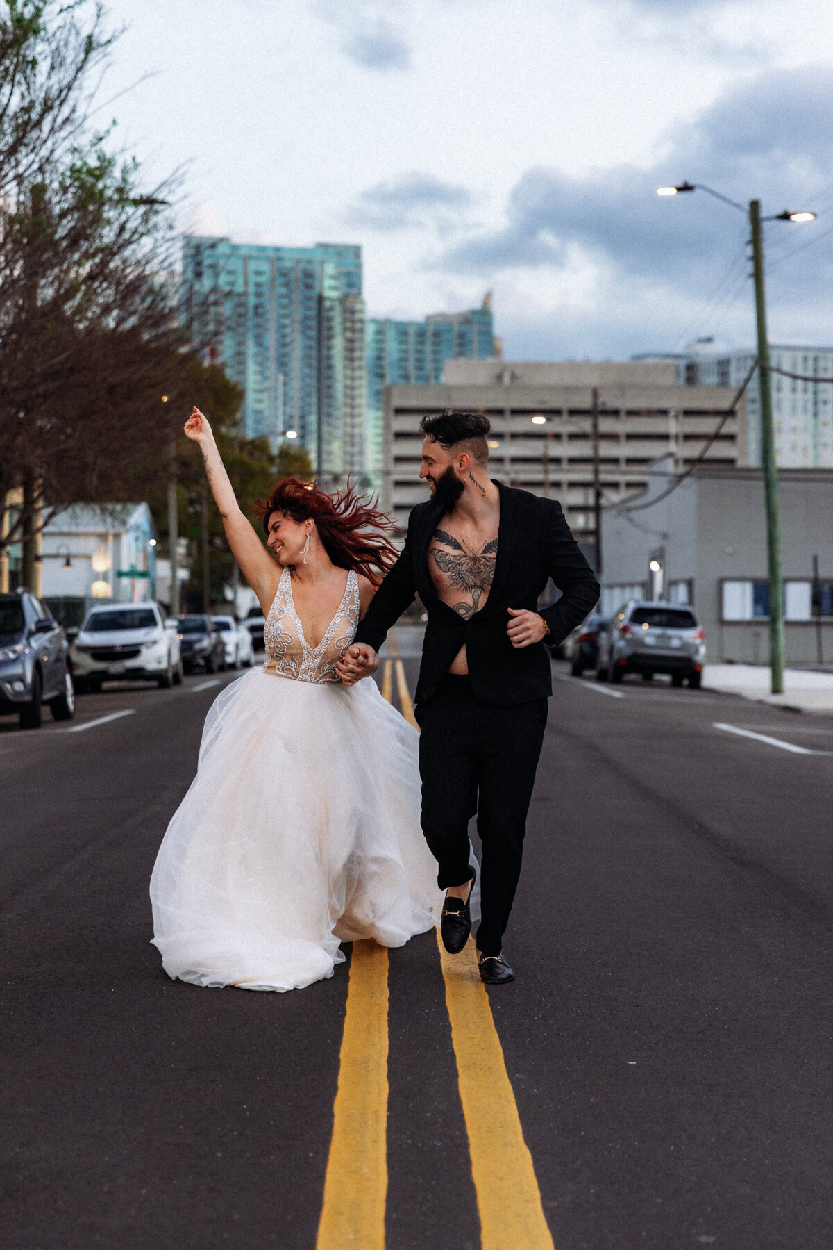 Shannon Lee, from Love Like Wild Photography, captures a joyful couple holding hands and running down a city street.