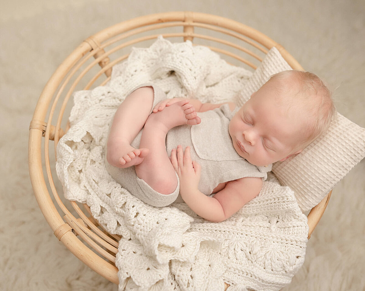 baby boy sleeping in wicker basket