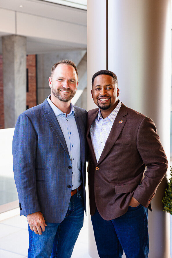 Two men pose together for their companies headshot session.