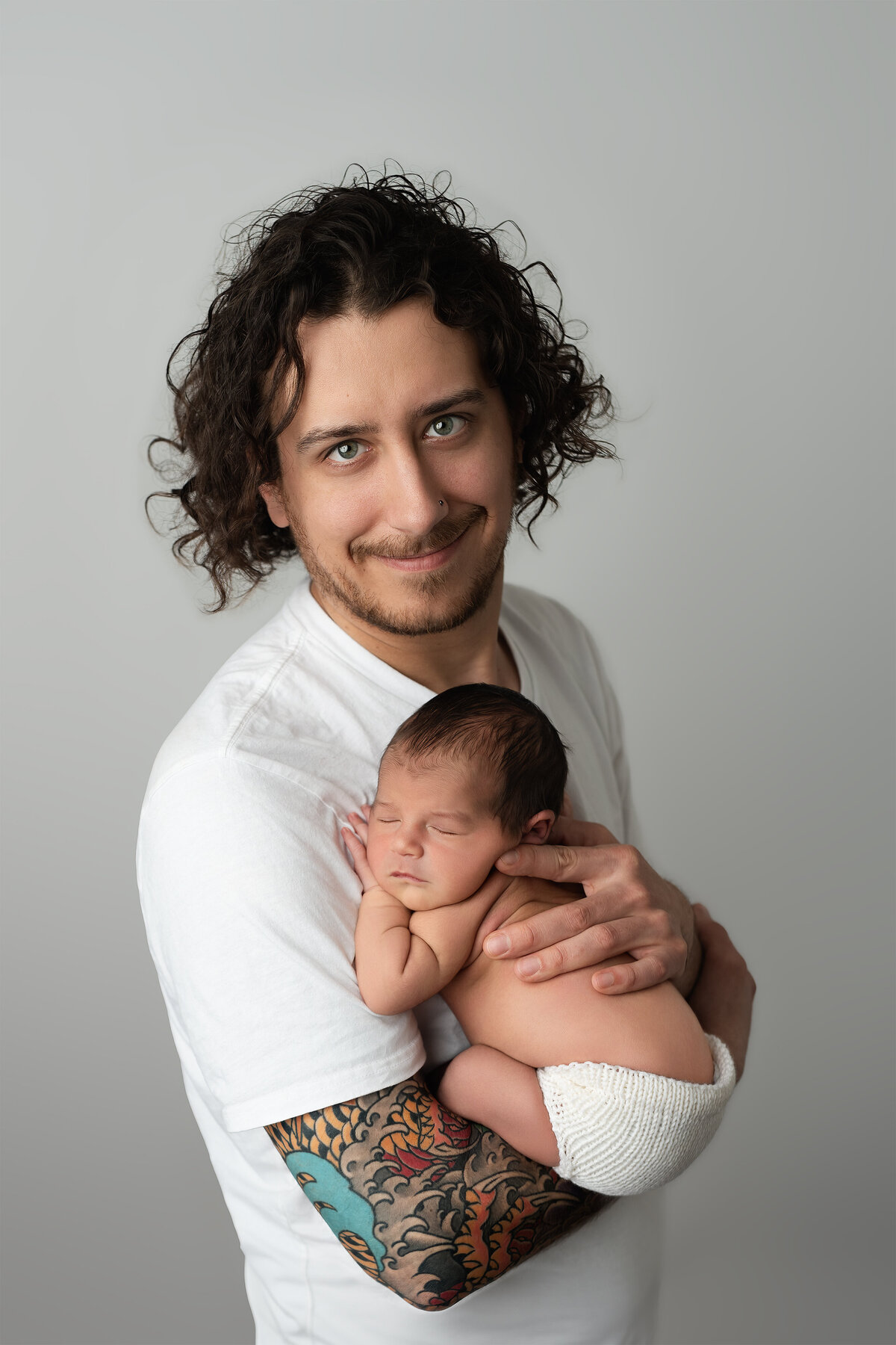 Studio family portrait of father gently cradling newborn | Paris Ontario photographer
