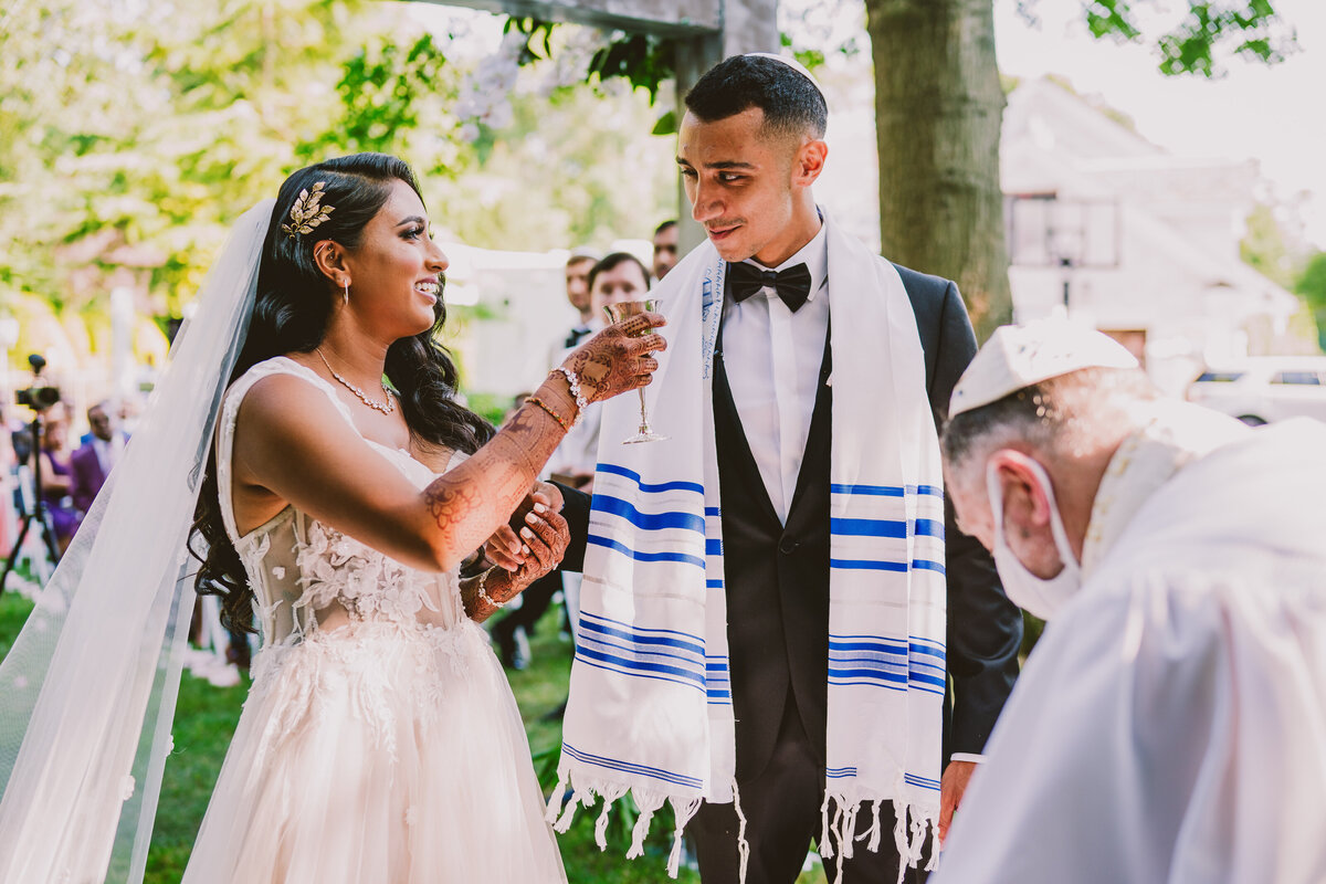 Bride share kiddush cup with the groom during the jewish wedding ceremony