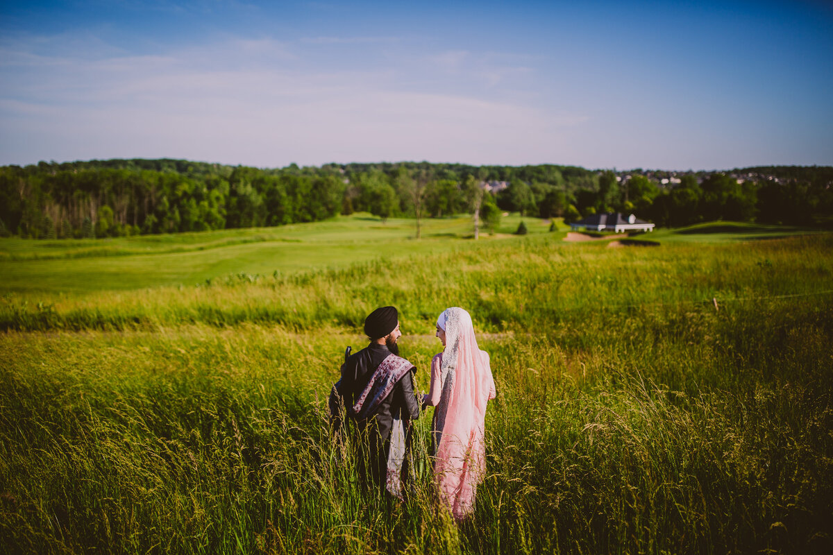 Sikh amritdhari couple walking along the open field on the wedding day in michigan