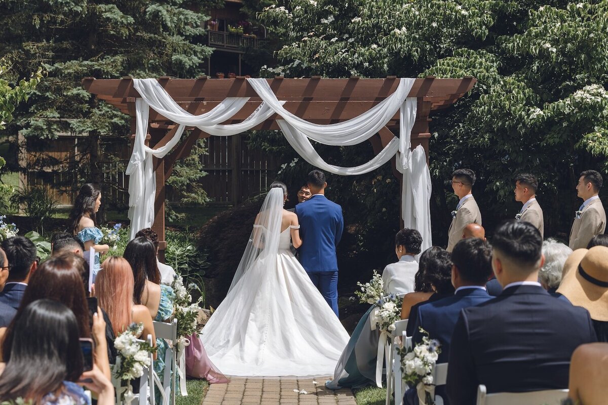 White draped wedding ceremony arch surrounded by greenery at Crystal Springs Resort