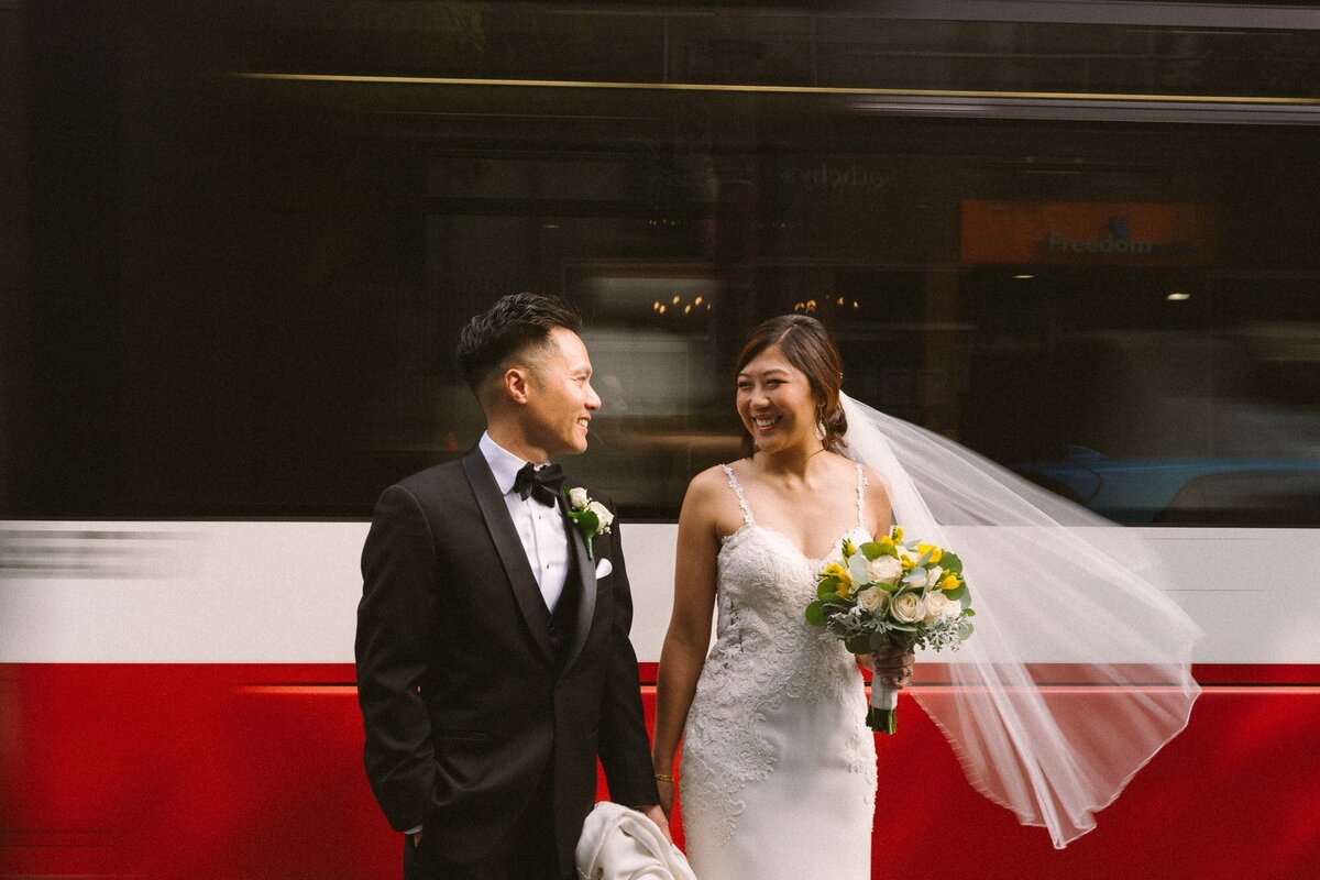 married couple standing looking at each other in front of a streetcar