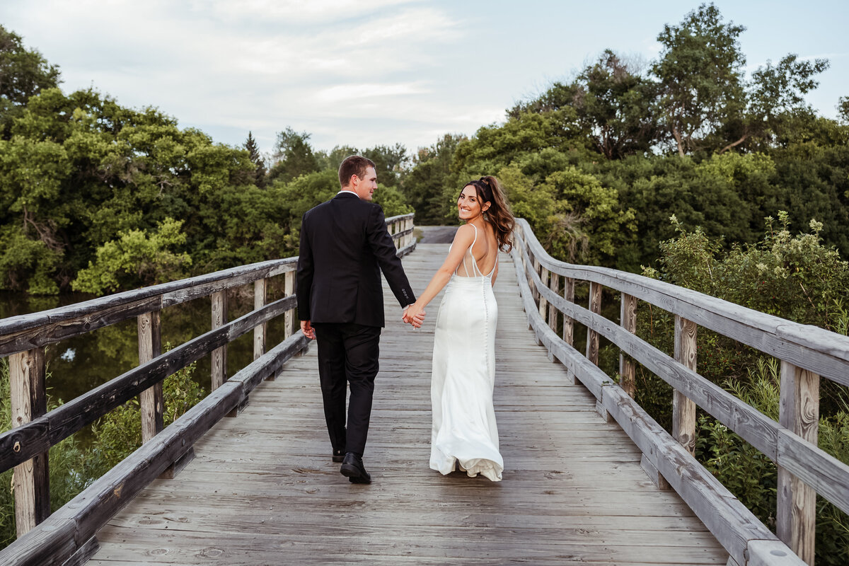 Wedding Couple walking on the bridge at Heart River Golf Course 