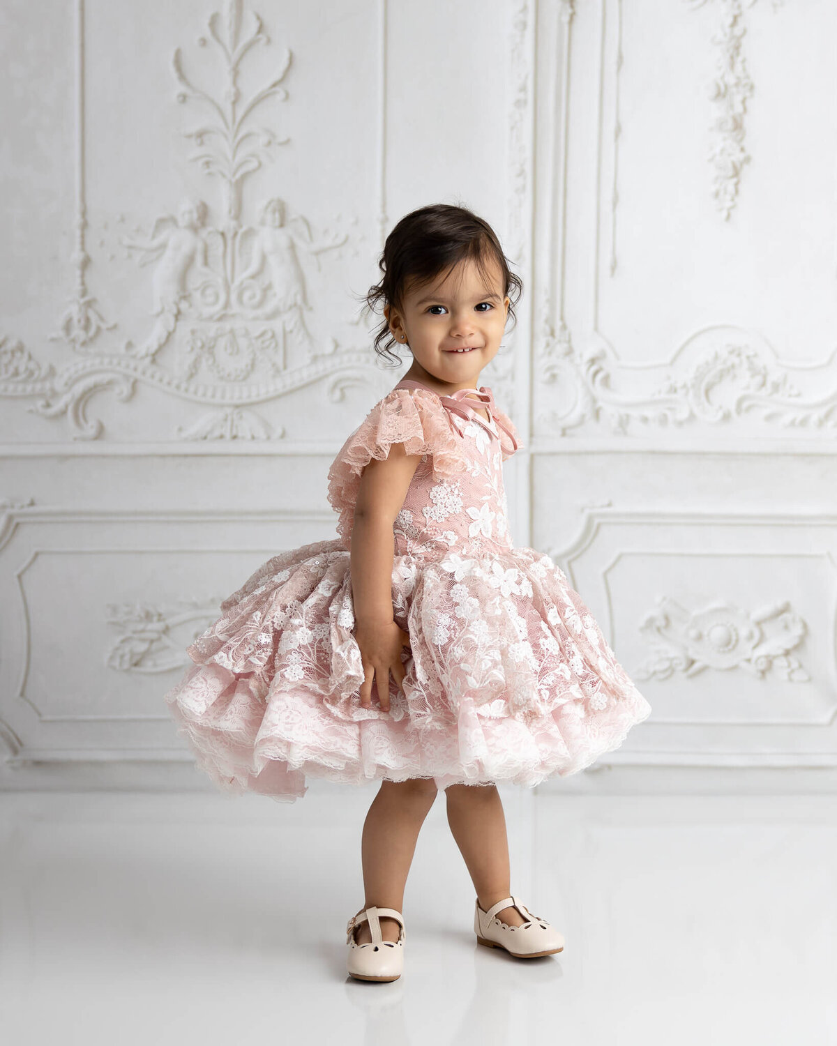 child wearing bentley and lace couture gown and smiling