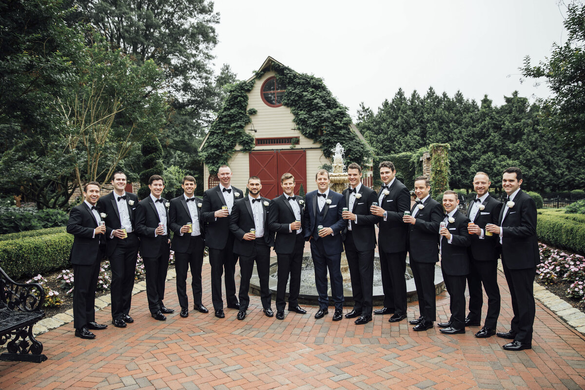 Ashford Estate | Groom and groomsmen toasting in front of ivy-covered barn during summer wedding | Allentown, New Jersey