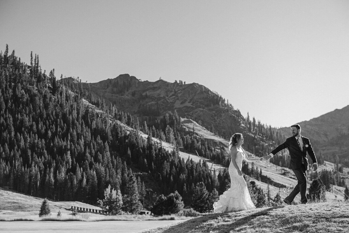 black and white image of bride and groom in Palisades Tahoe with KT-22 in background