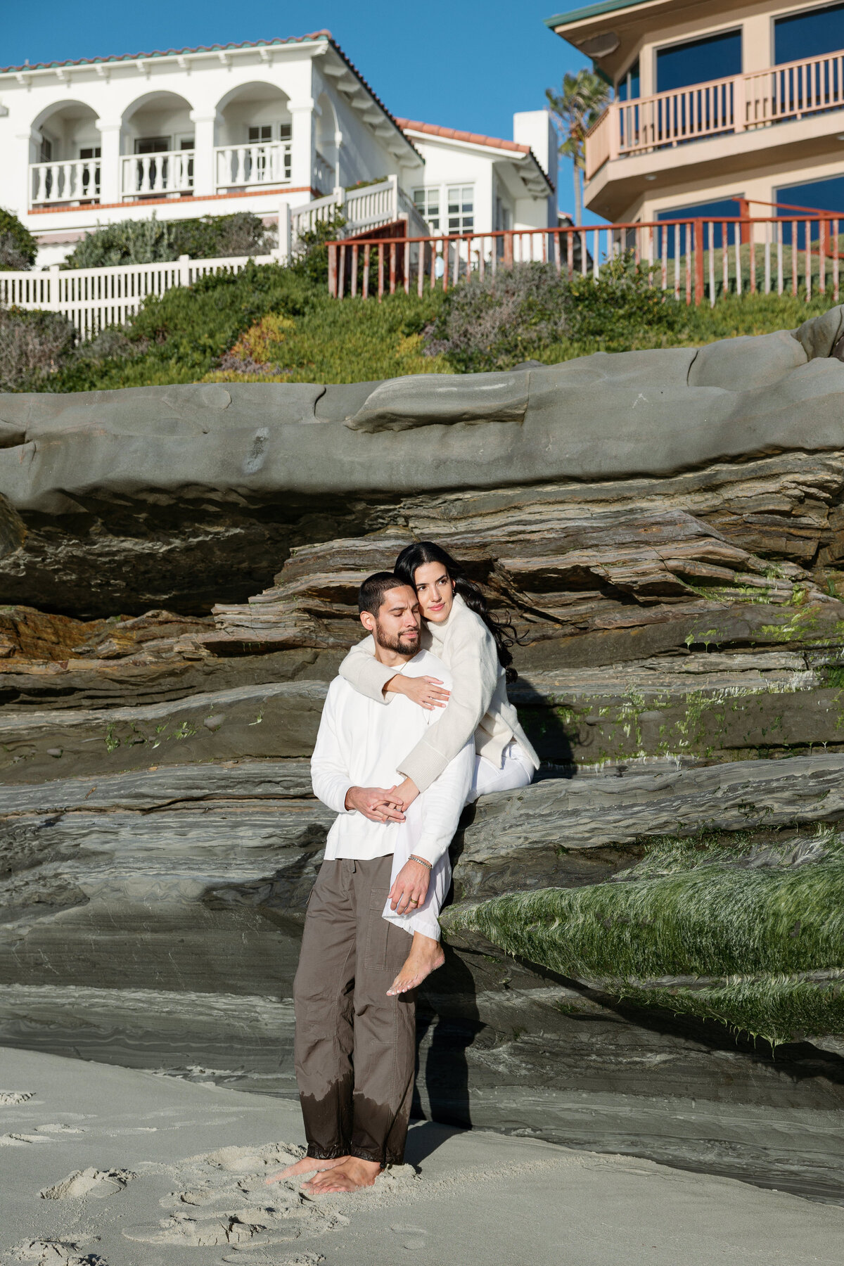 Beautiful sunset engagement photo of the couple on a cliffside in La Jolla California, capturing a romantic moment.